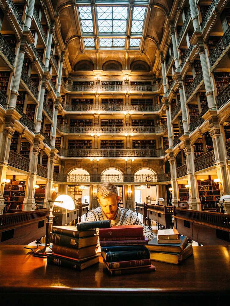 Man reading translated books in a foreign library