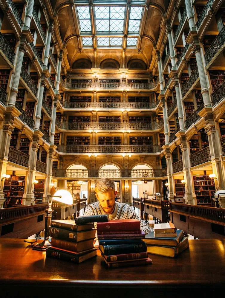 Man reading translated books in a foreign library